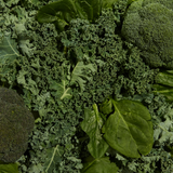 Close-up of green leafy vegetables including broccoli and kale.