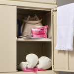 Beige locker with boxing gloves, pink bags, and a white towel inside.