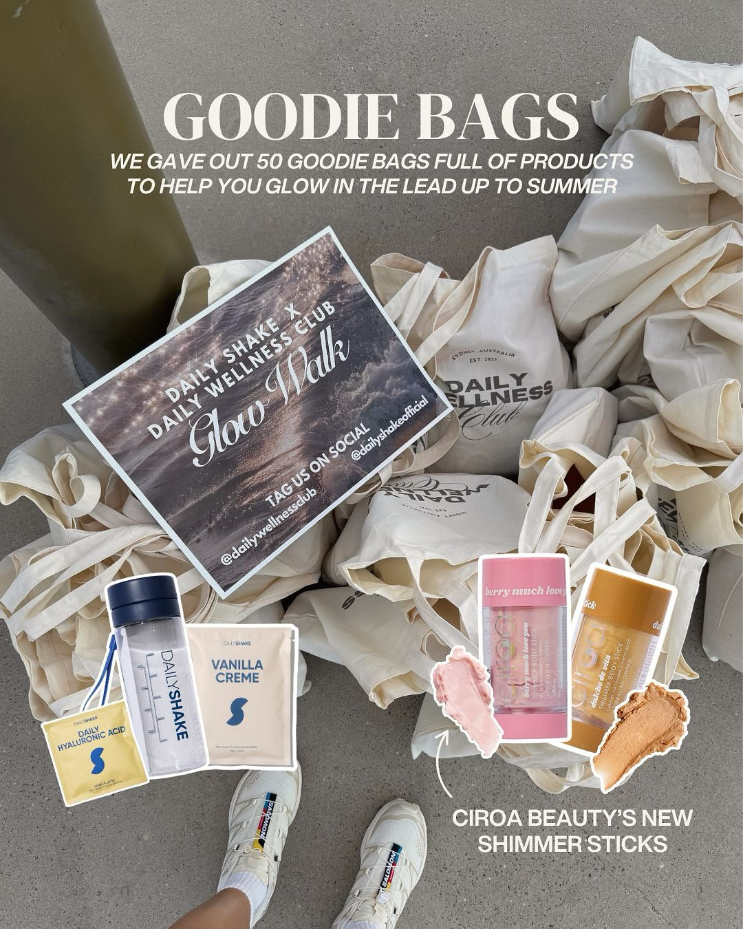 Goodie bags with Daily Wellness Club products and Ciroa Beauty shimmer sticks on a gray surface.